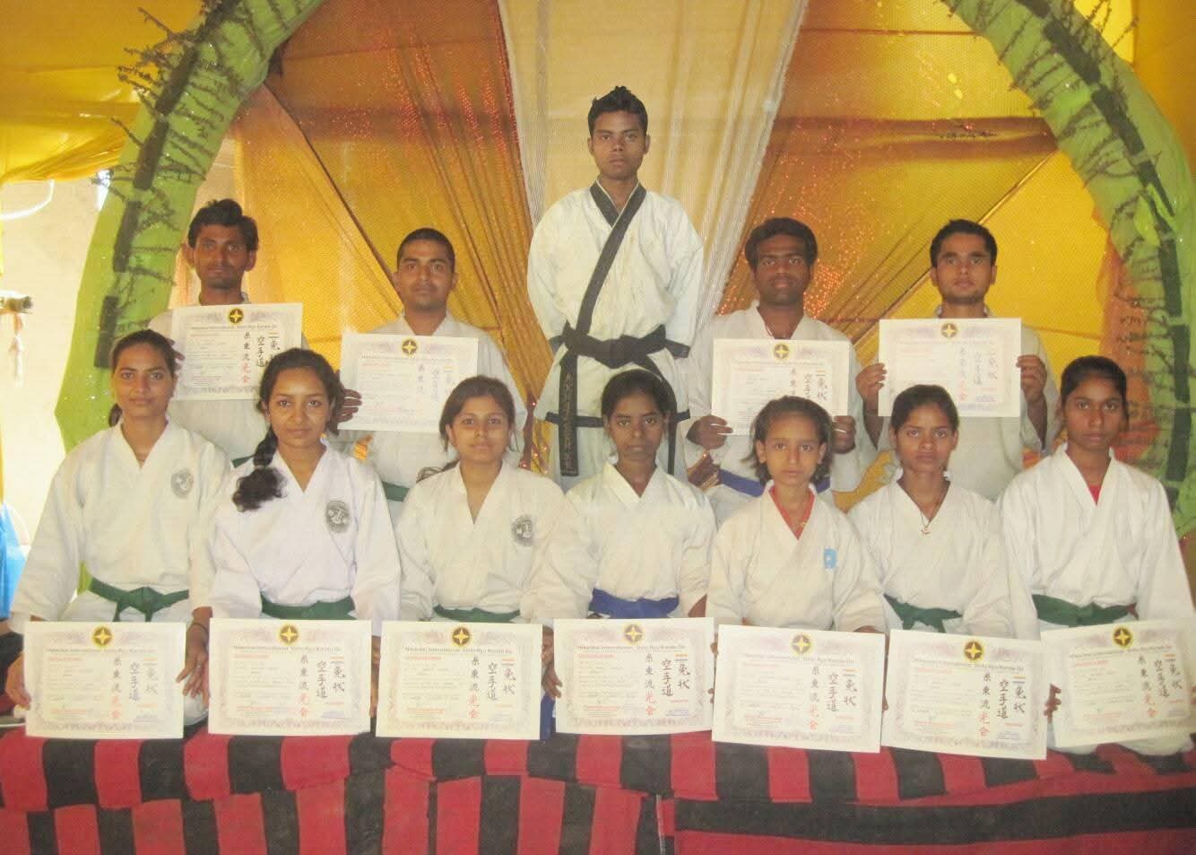 Activity Zone students holding their official karate grading certificates after belt examination