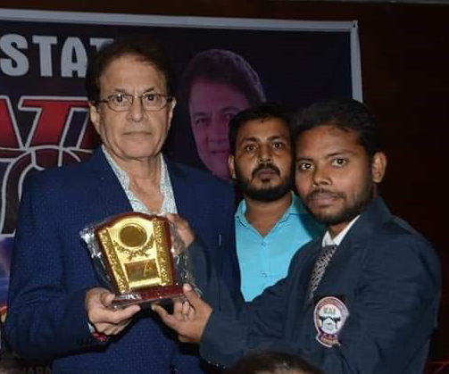 Rensei Akhilesh Kumar receiving memento from senior official at a state karate event