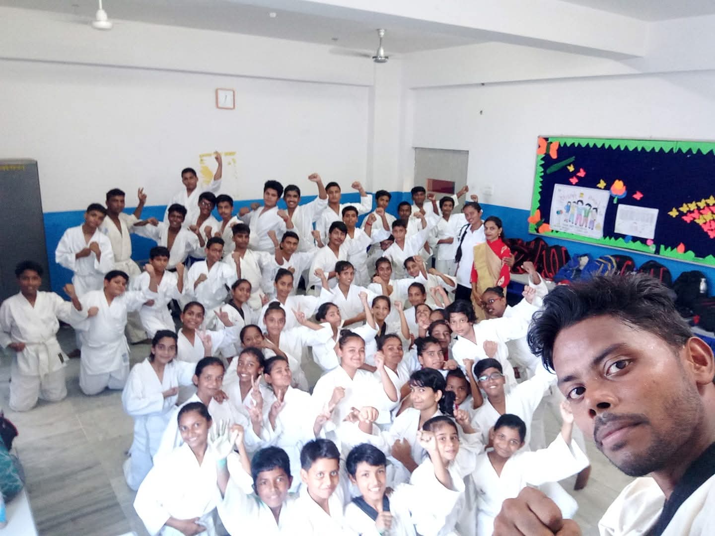 Large group of Activity Zone karate students in white gi celebrating after training session